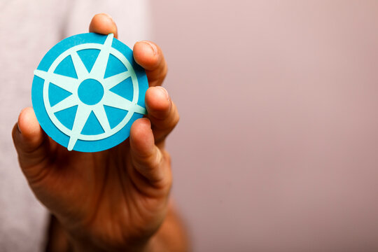 A hand holds a blue circular symbol, representing direction, guidance, or cloud technology.