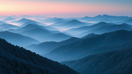 Fototapeta premium Misty mountain range layers with soft blue tones during early sunrise