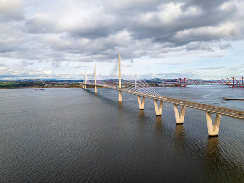 Aerial view of the Queensferry Crossing bridge spanning the Firth of Forth with the historic Forth Bridge in the background, South Queensferry, United Kingdom.