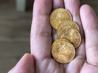 Hand Holding Swiss 20 Francs Vreneli Gold Coins © Vertstyle