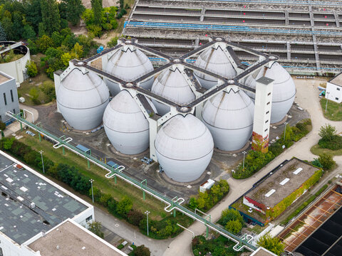 Aerial view of the egg-shaped digester tanks at the Klarwerk Ruhleben sewage treatment plant, surrounded by industrial infrastructure and greenery in Berlin, Berlin, Germany.