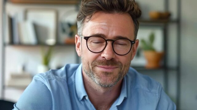 Smiling Middle-Aged Man with Beard and Glasses in a Blue Shirt