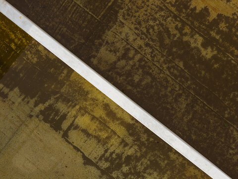 Aerial view of abstract industrial concrete structures and textures with a sharp diagonal line in Diepenbeek, Flanders, Belgium.