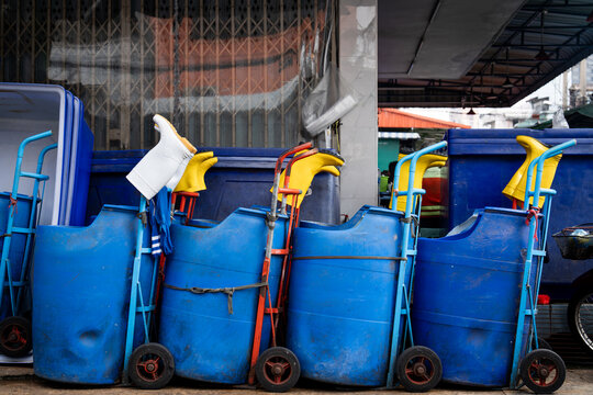 Blue plastic barrels on trolleys with rubber boots at a Bangkok market