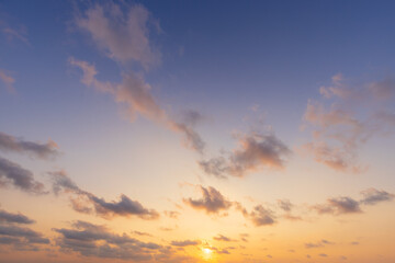 Fototapeta premium Pastel Sunset Sky Background with Soft Golden Clouds,A serene sunset sky background featuring soft pastel purple tones and gentle golden clouds. Ideal for nature, background, travel, and inspiring cop