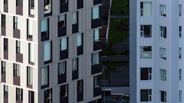 Aerial view of modern apartment complex with geometric metal cladding and windows in Iceland.