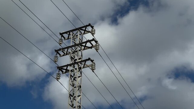 Electricity pylon and power lines against clouds in Gandia, Spain