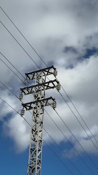Vertical video of an electricity pylon against clouds in Spain