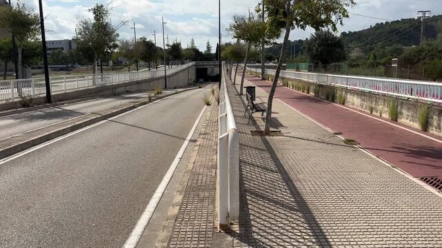 Empty road and red cycle lane running into a tunnel in Spain
