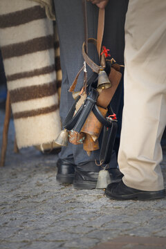 Shepherd holding traditional cowbells on leather straps at a transhumance festival in Serra da Estrela, Portugal