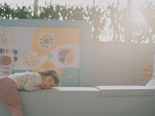 Sleeping child resting on an airport bench before a colorful mural © visualstory