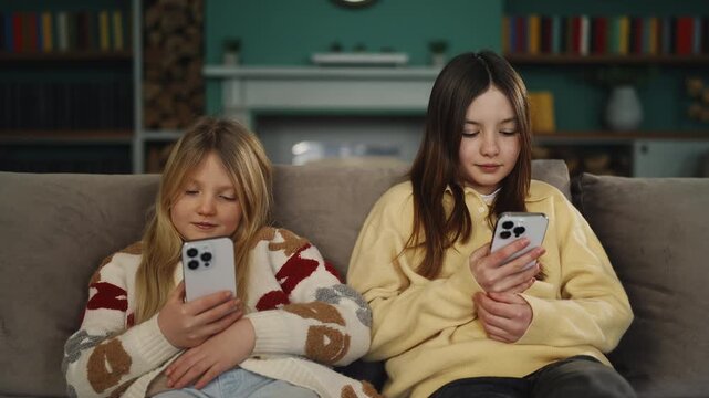 Siblings scroll social media on phones, showing excessive gadget use