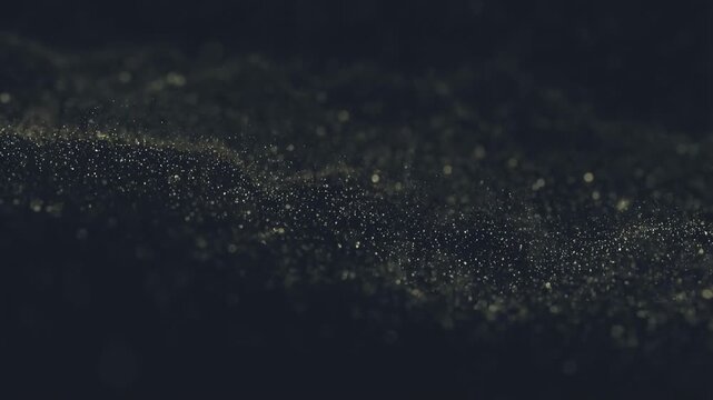 Shimmering particles drift through a dark granular atmosphere. Title sequences, motion graphics backdrops, and luxury brand.