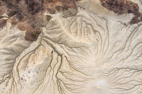 Aerial view of the Mud Volcanoes Paclele Mari showing the unique, cracked, and eroded landscape with intricate patterns formed by mud flows in Paclele, Buzau County, Romania.