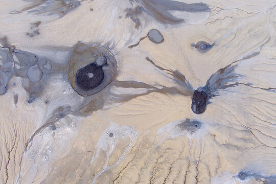 Aerial view of the mud volcanoes at Vulcanii Noroiosi Paclele Mari, showcasing unique geological formations, grey mud craters, and dry cracked earth patterns in Paclele, Buzau County, Romania.