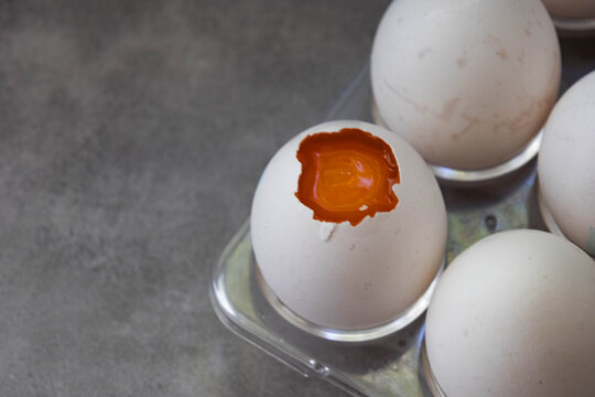 Eggs in a plastic palette with one egg cracked.