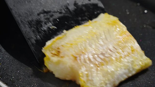 Frying white fish fillets. Frying hake fillets in a hot pan Detailed image of lightly seared fish with tender interior and crisp coating. Vivid portrayal of gently cooked whitefish