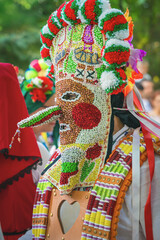 Obraz premium Portrait of kuker. Close up of ornate Bulgarian festival mask with colorful beads, poms and ribbons. Detailed cultural folk costume craftsmanship, ritual symbolism, decorative costume design