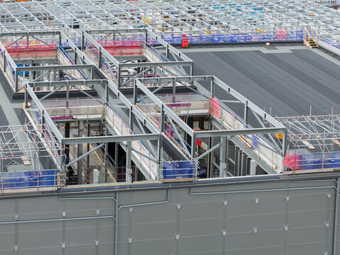 Aerial view of a data center under construction featuring steel framework, scaffolding, and roofing elements in the United Kingdom.