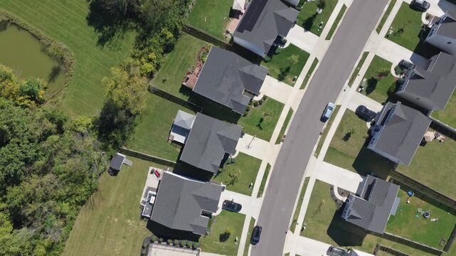 Drone aerial view of suburban rural neighborhood homes, houses,  neighbors, and family residential units in housing market by central Ohio city town Springfield, OH by countryside roads and streets 4k