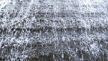 Close Up View Of Water Droplets Falling Naturally Onto Rock Surface © md