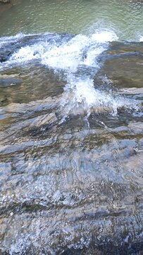 Natural Water Stream Flowing Over Rocky Surface Creating White Foam