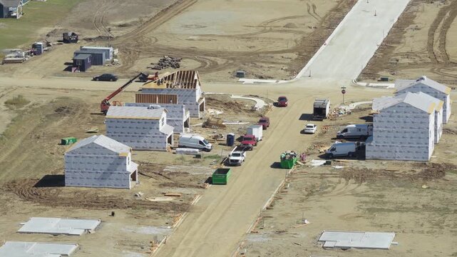 Drone aerial of newly built and constructing suburban neighborhood homes on new streets as construction of multiple buildings for housing market increase residential houses near Springfield Ohio town