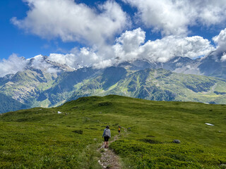 Obraz premium Hikers walking along alpine trail facing Mont Blanc, France
