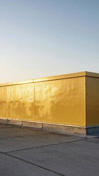 Vertical video: Camera starting pan on rooftop, revealing yellow parapet and seams, showing glint