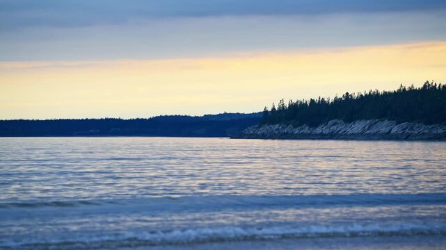 New River Beach Provincial Park sandy tidal shoreline under dramatic overcast twilight skies along the Bay of Fundy, New Brunswick.