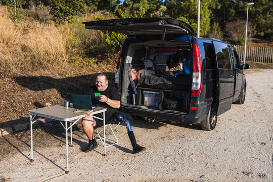 Man with prosthetic leg shopping online camping van