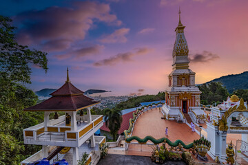 Fototapeta premium Golden Sunset Over a Beautiful Buddhist Temple on Patong Mountain, Phuket, Thailand, Surrounded by Tropical Hills and Dramatic Evening Skies Pa Tong Phuket island Thailand 