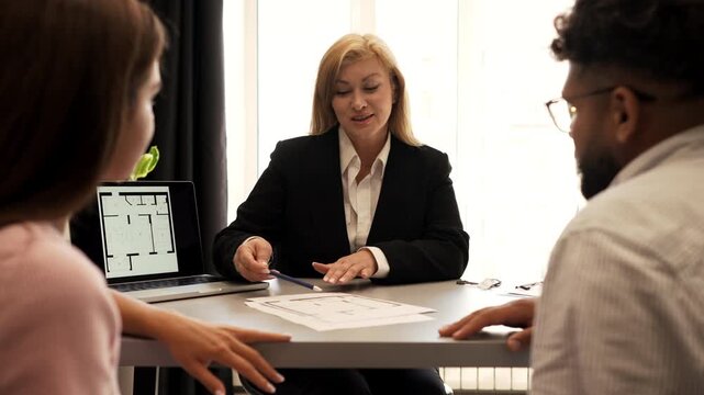 Real estate agent meeting a couple for a house plan consultation