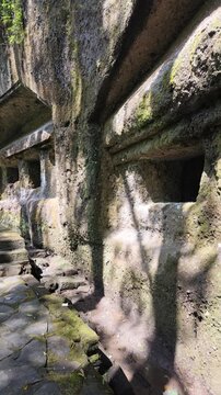 Ancient stone rock carved shrines at Gunung Kawi temple in Bali, mossy cliffs and historic architecture, sacred archaeological site, traditional Balinese heritage, travel adventure, spiritual