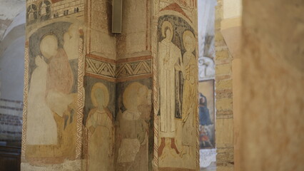 Ancient religious frescoes on stone pillars inside the Romanesque crypt of San Fermo Church in Verona, Veneto. © cenz07