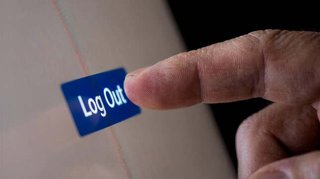 Finger clicking logout button on computer screen for account security and privacy