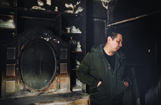 Man inspecting fire-damaged room after a devastating accident