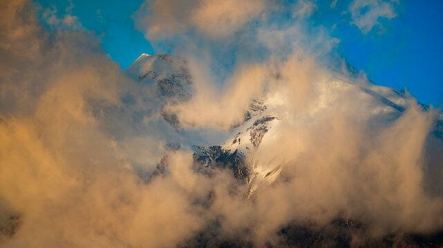 Cotopaxi volcano peak emerging through golden clouds