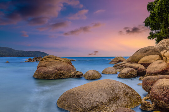 Long Exposure Seascape of Kata Beach with Rocky Shoreline and Tropical Forest, Phuket, Thailand