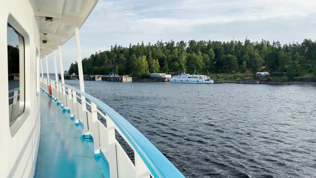 A cruise ship sails past a scenic dock at Valaam, Lake Ladoga. This relaxing journey brings calm and happy feelings.