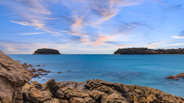 Long Exposure Seascape of Kata Beach with Rocky Shoreline and Tropical Forest, Phuket, Thailand