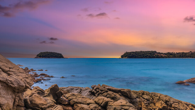 Long Exposure Seascape of Kata Beach with Rocky Shoreline and Tropical Forest, Phuket, Thailand