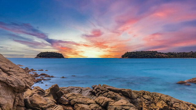 Long Exposure Seascape of Kata Beach with Rocky Shoreline and Tropical Forest, Phuket, Thailand