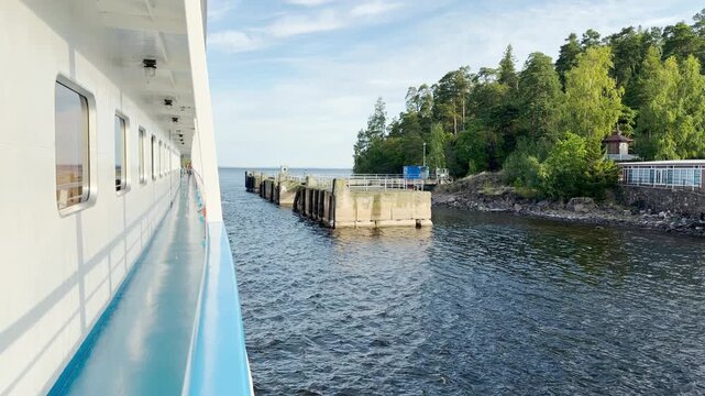 A cruise ship approaches a pier at Valaam on Lake Ladoga. This scenic approach brings calm and happy feelings during a relaxing journey.