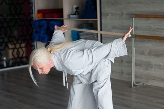 Senior woman practice qigong balance exercise with resistance band