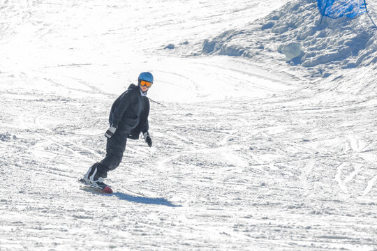 Young woman snowboarding down a sunny winter slope