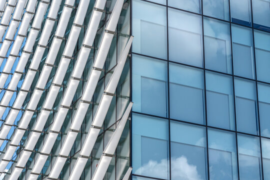 Modern glass office building facade with curved sunshades