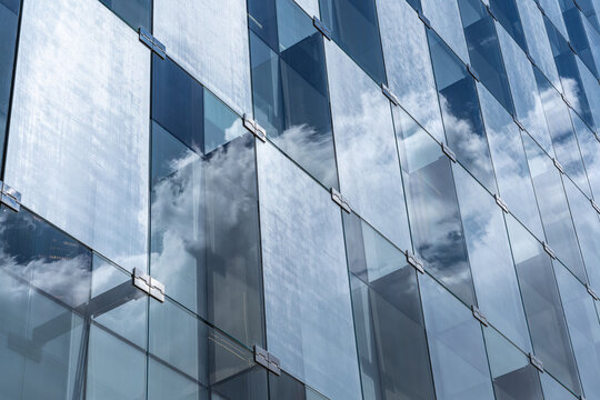Glass facade of modern office building with cloud reflection