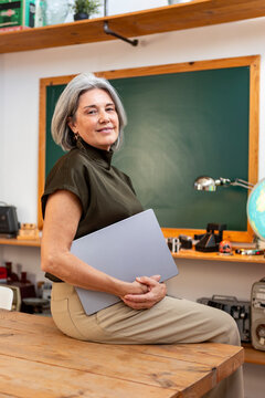 Mature woman with laptop in informal office workspace