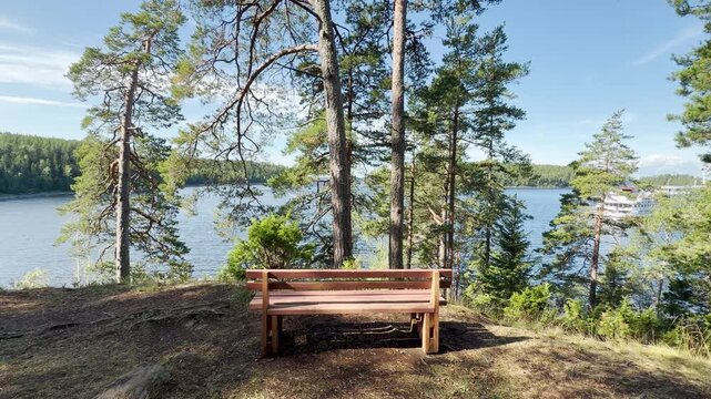 A wooden bench stands empty overlooking the water on Valaam, Lake Ladoga. This quiet scenic spot evokes a deeply peaceful, relaxing, and lonely feeling.